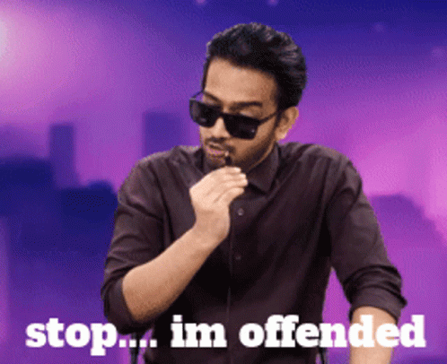A Man Wearing Sunglasses And A Black Shirt Is Smoking An Electronic Cigarette With The Words Stop Im Offended Behind Him GIF