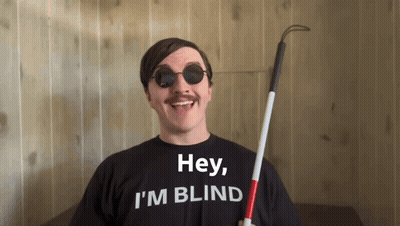A Man Wearing Sunglasses And A Black Shirt That Says Hey I 'M Blind GIF