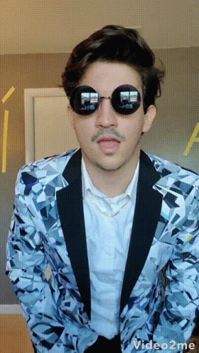 A Man Wearing Sunglasses And A Blue Jacket Has A Video2me Watermark GIF
