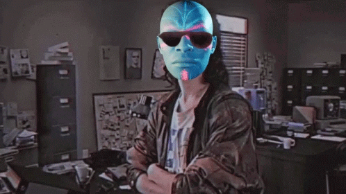 A Man Wearing Sunglasses And A Blue Mask Is Standing In Front Of A Sign That Says Hackerman GIF