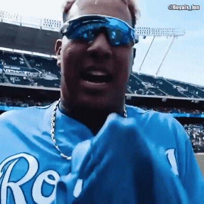 A Man Wearing Sunglasses And A Blue Royals Shirt GIF