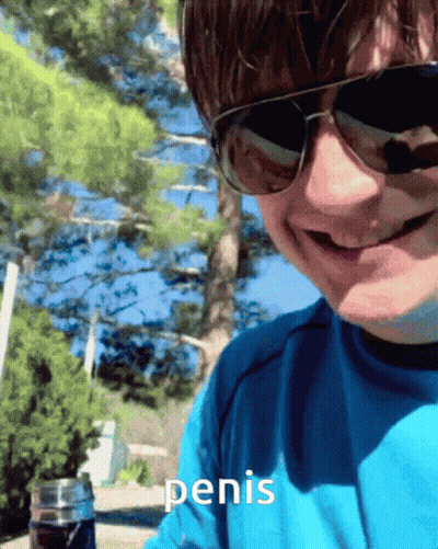 A Man Wearing Sunglasses And A Blue Shirt Has The Word Penis Written On His Shirt GIF