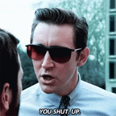 A Man Wearing Sunglasses And A Blue Shirt Is Saying You Shut Up GIF