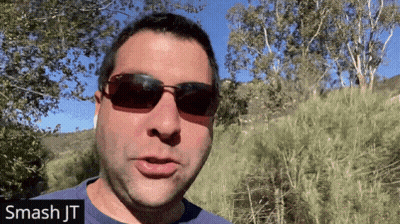 A Man Wearing Sunglasses And A Blue Shirt With The Name Smash Jt On The Bottom Right GIF