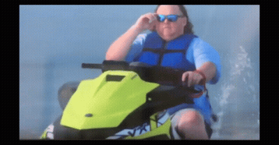 A Man Wearing Sunglasses And A Blue Vest Is Riding A Jet Ski GIF