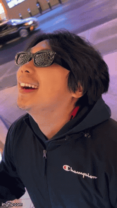 A Man Wearing Sunglasses And A Champion Jacket Smiles GIF