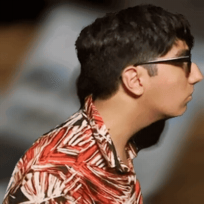 A Man Wearing Sunglasses And A Colorful Shirt Looks To The Side GIF