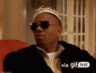A Man Wearing Sunglasses And A Crown Sitting On A Couch . GIF
