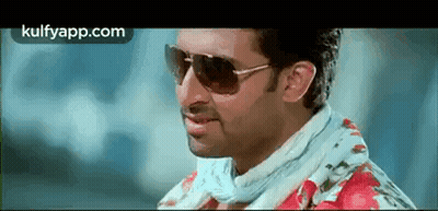 A Man Wearing Sunglasses And A Floral Shirt Is Smiling And Looking At The Camera . GIF