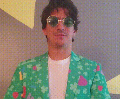 A Man Wearing Sunglasses And A Green Jacket Is Making A Funny Face . GIF