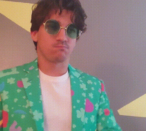 A Man Wearing Sunglasses And A Green Jacket With The Letter L On It GIF