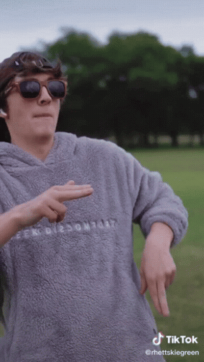 A Man Wearing Sunglasses And A Grey Sweater With The Word Comfort On The Front GIF