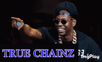 A Man Wearing Sunglasses And A Hat Is Holding A Microphone In Front Of A True Chainz Logo GIF