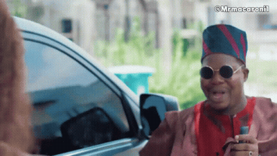 A Man Wearing Sunglasses And A Hat Is Talking To A Woman In Front Of A Car With The Caption Mrmacaronii GIF