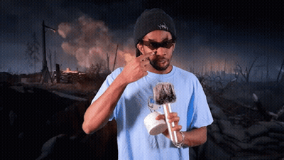 A Man Wearing Sunglasses And A Hat That Says ' Snoop Dogg ' On It Holds A Microphone GIF