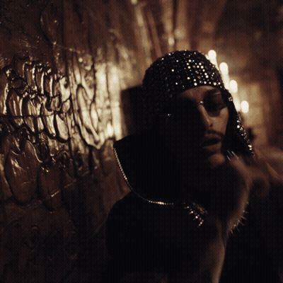 A Man Wearing Sunglasses And A Hat With Sequins On It GIF