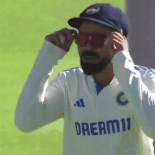 A Man Wearing Sunglasses And A Hat With The Word Dream11 On His Shirt . GIF