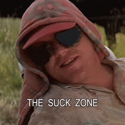 A Man Wearing Sunglasses And A Hat With The Words The Suck Zone Above Him GIF
