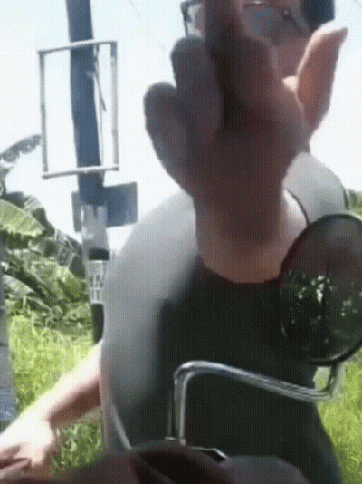 A Man Wearing Sunglasses And A Helmet Giving The Middle Finger GIF
