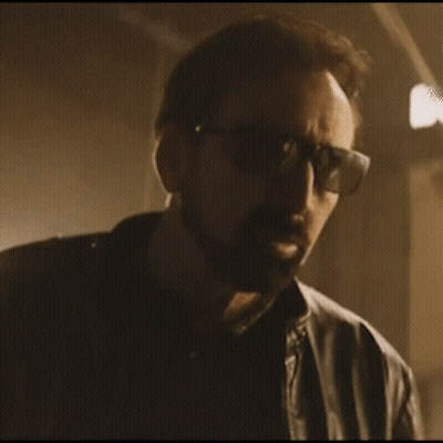 A Man Wearing Sunglasses And A Leather Jacket Is Looking At The Camera GIF