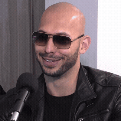 A Man Wearing Sunglasses And A Leather Jacket Is Smiling GIF