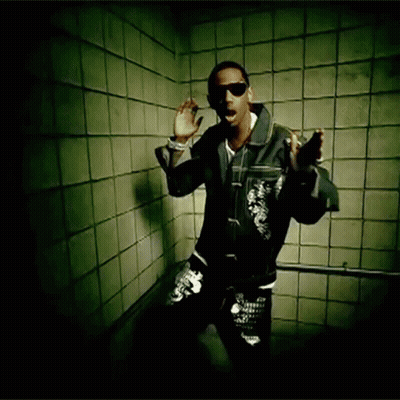 A Man Wearing Sunglasses And A Leather Jacket Stands In Front Of A Tiled Wall GIF