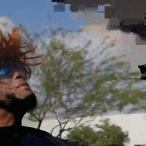 A Man Wearing Sunglasses And A Mohawk Looks Up Into The Sky GIF