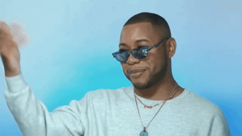 A Man Wearing Sunglasses And A Necklace With The Name Chris On It GIF