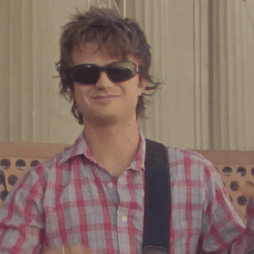 A Man Wearing Sunglasses And A Plaid Shirt Makes A Heart Shape With His Hands GIF