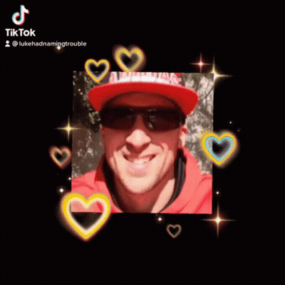 A Man Wearing Sunglasses And A Red Hat Is Smiling For The Camera GIF