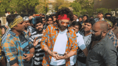 A Man Wearing Sunglasses And A Red Headband Is Surrounded By People GIF