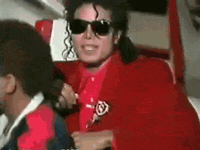 A Man Wearing Sunglasses And A Red Jacket Has A Badge On His Jacket GIF