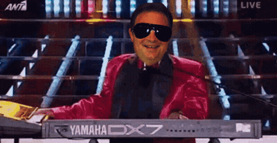 A Man Wearing Sunglasses And A Red Jacket Is Playing A Yamaha Dx7 Keyboard GIF