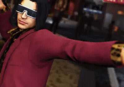 A Man Wearing Sunglasses And A Red Jacket Is Standing In A Street . GIF