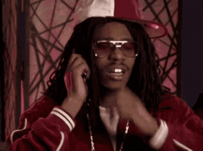 A Man Wearing Sunglasses And A Red Jacket Is Talking On A Cell Phone With The Word Hhh Above Him GIF