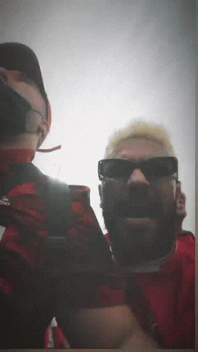 A Man Wearing Sunglasses And A Red Shirt With Adidas On It GIF