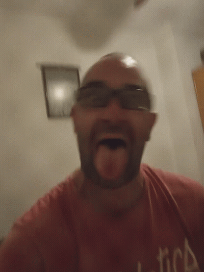 A Man Wearing Sunglasses And A Red Shirt With The Word America On It GIF