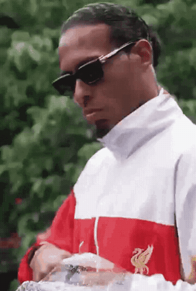 a man wearing sunglasses and a red white and blue jacket with the letter l on the front