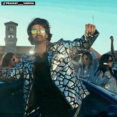 A Man Wearing Sunglasses And A Silver Jacket Is Dancing GIF