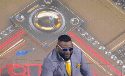 A Man Wearing Sunglasses And A Suit Holds Up A Large Omg Sign GIF