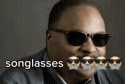 A Man Wearing Sunglasses And A Suit With The Words Songglasses Written On It . GIF