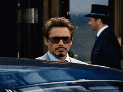 A Man Wearing Sunglasses And A Top Hat Is Looking Out Of A Car Window GIF