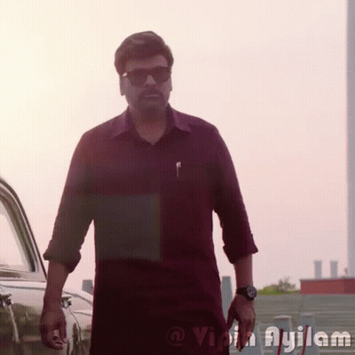 A Man Wearing Sunglasses And A Watch Is Standing In Front Of A Car With The Word Ayilam On The Bottom Right GIF