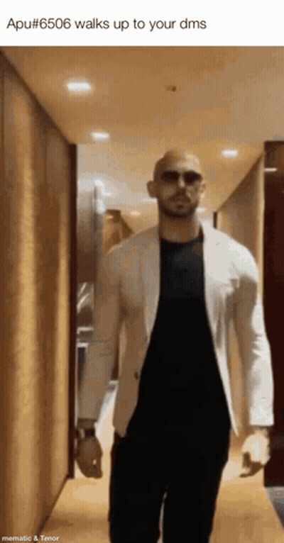 A Man Wearing Sunglasses And A White Jacket Walks Up To His Dms GIF