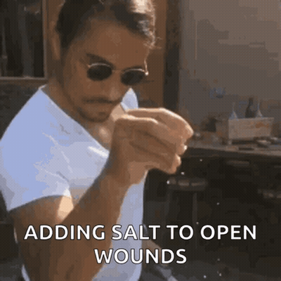 a man wearing sunglasses and a white shirt is adding salt to open wounds .