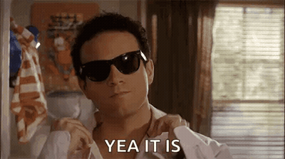 A Man Wearing Sunglasses And A White Shirt Is Adjusting His Shirt And Says `` Yea It Is '' . GIF