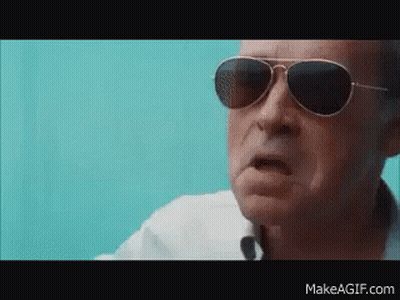 A Man Wearing Sunglasses And A White Shirt Is Making A Funny Face GIF