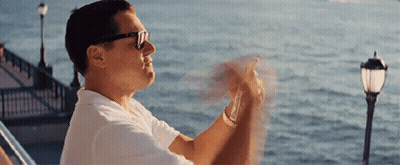 A Man Wearing Sunglasses And A White Shirt Is Sitting On A Boat Looking At The Ocean . GIF