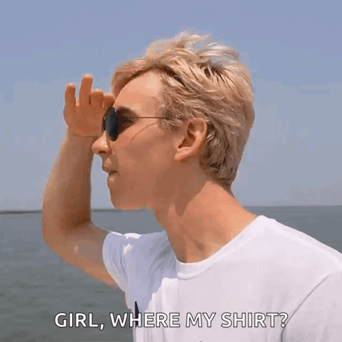 A Man Wearing Sunglasses And A White Shirt Is Standing On A Boat And Looking At The Water . GIF