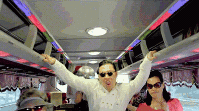 A Man Wearing Sunglasses And A White Shirt Stands In A Bus With His Arms Outstretched GIF